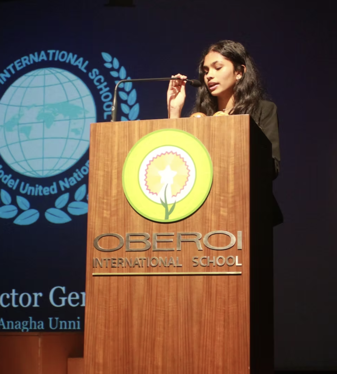Anagha Unni speaking at a podium